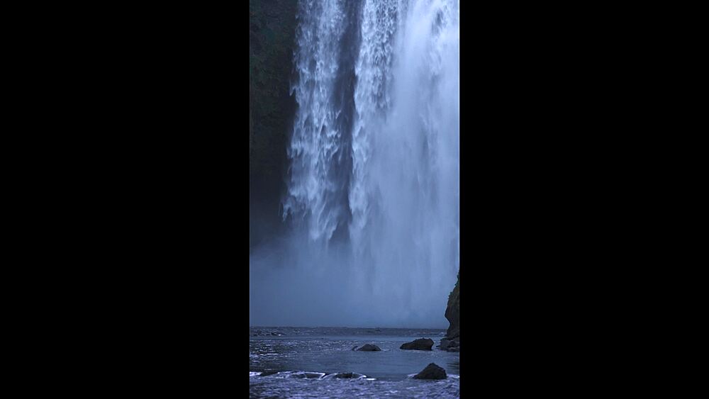 Locked-off frame at Skogafoss base as dusk falls mood shot for nature docs, the Southern Region, Iceland