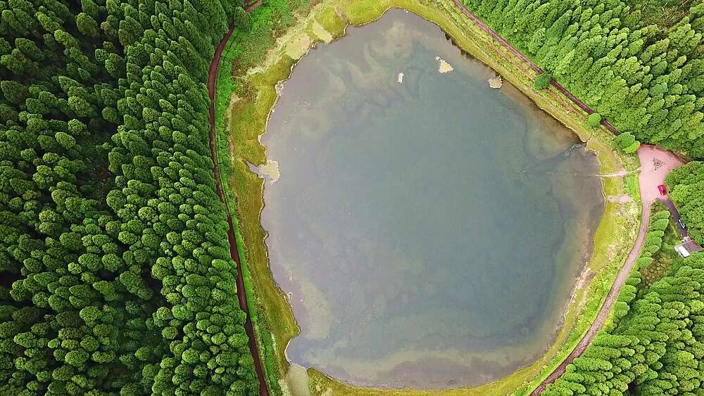 Top-down drone over a calm circular Empadadas crater lake, Sao Miguel, Azores, Portugal