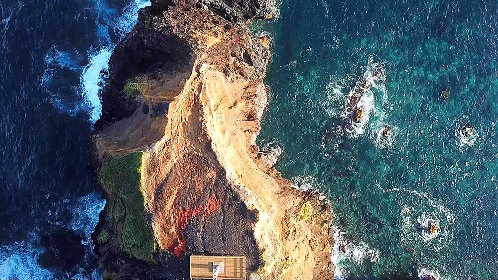 Forward drone flight traces a basalt promontory to its tip above the Atlantic, Fenais da Ajuda, Sao Miguel, Azores