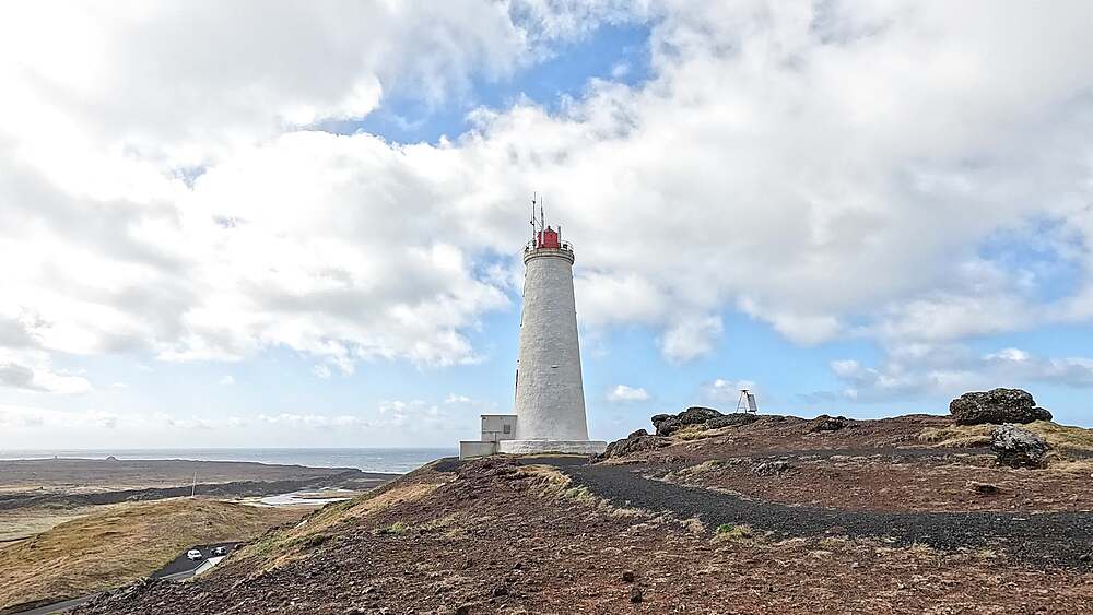 Reykjanesviti lighthouse from hilltop with coastal lava plain and Atlantic Ocean beyond, Reykjanes, Iceland