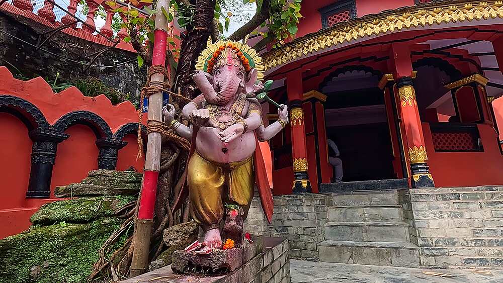 Dolly toward a garlanded pink Ganesha statue at the Gupteshwor Mahadev Cave temple, Pokhara, Nepal