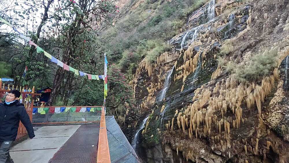 Stone shrine of Pojenhyam Baraha Than with brass bells and prayer flags, Annapurna, Nepal
