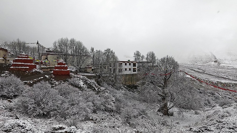 Snowy Monastery with red chortens at Lo Gekar (Ghar Gompa) hillside, Upper Mustang, Nepal