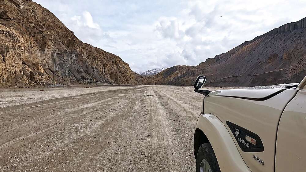 POV driving wide gravel riverbed between canyon walls, Kali Gandaki, Upper Mustang, Nepal