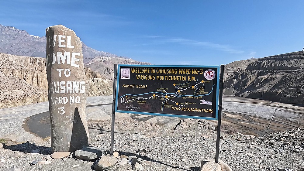 Welcome to Chhusang stone sign painted trail map Mustang Nepal mountains
