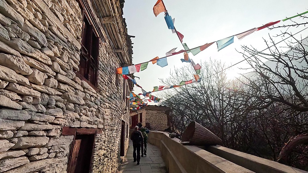 Snow Leopard Guest House lane prayer flags people walking Marpha Mustang Nepal