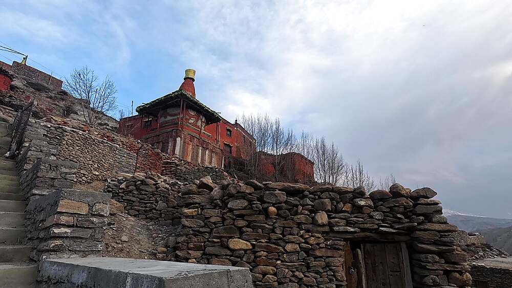 Red monastery chorten stone terraces hillside Ghiling Upper Mustang Nepal Buddhist