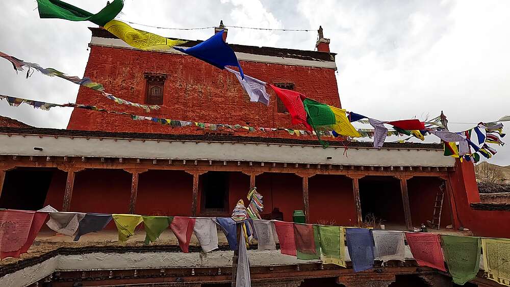 Jampa Lhakhang Monastery red facade prayer flags low angle Lo Manthang Upper Mustang Nepal