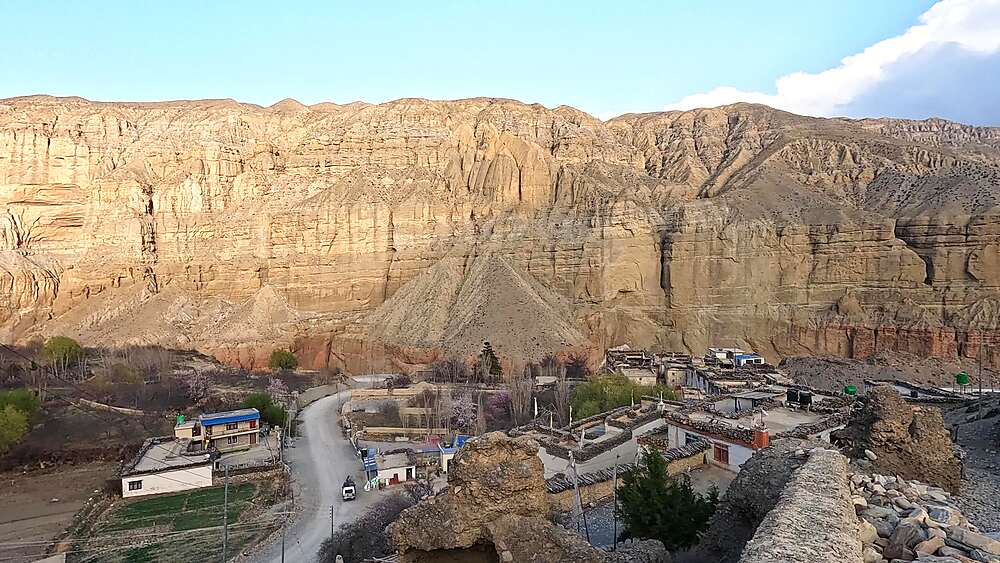 Chele village in distance, eroded badlands cliffs, winding mountain road, Upper Mustang Nepal