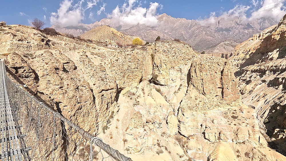 View from suspension bridge into eroded canyon formations, gorge below, Upper Mustang Nepal