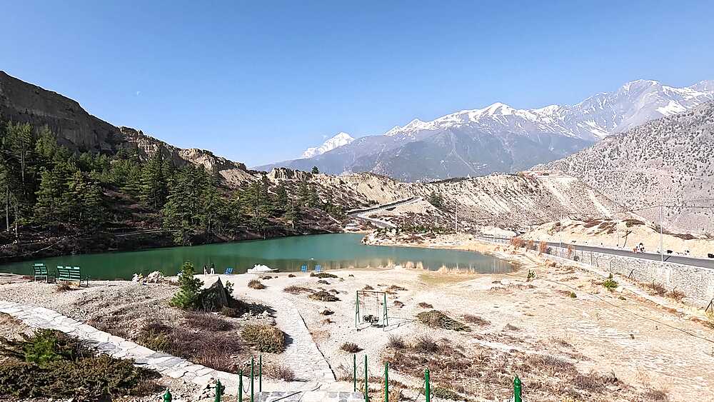 Alpine turquoise lake surrounded by cliffs, snow-capped peaks, pristine mountain lake Nepal