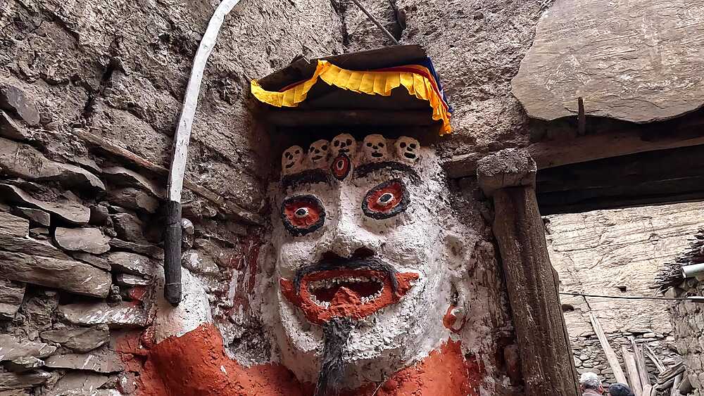 Tibetan male Ghost eater statue. protective deity figure, carved stone with painted eyes, gold crown, Kagbeni, Mustang Nepal