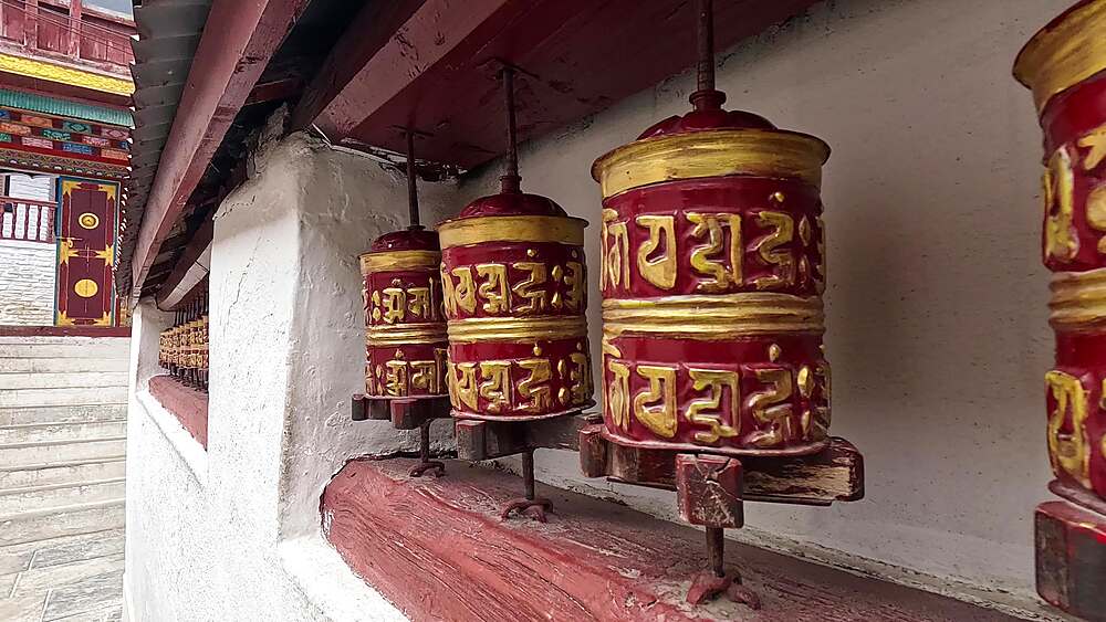 Close-up dolly in prayer wheels red-gold decorated, Buddhist shrine Samten Choling Gompa