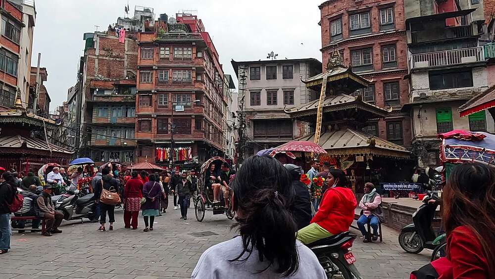 Kathmandu Durbar Square area, decorated cycle rickshaws carrying tourists past old Newari buildings and pagoda temple, Nepal