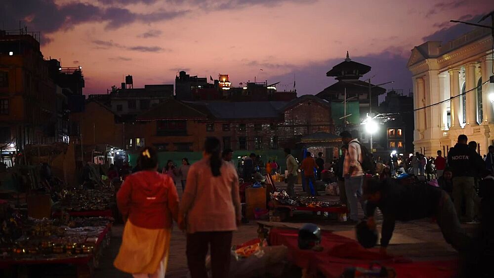View over the Basantapur Dabu market at dusk, stalls beneath a violet twilight sky with pagoda roofs, Kathmandu, Nepal