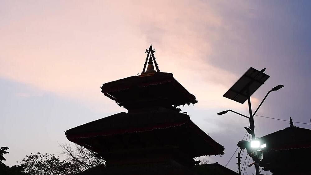 Silhouetted tiered pagoda roofs of Bhuvaneshwar Mahadev Temple against a pink twilight sky, Kathmandu, Nepal