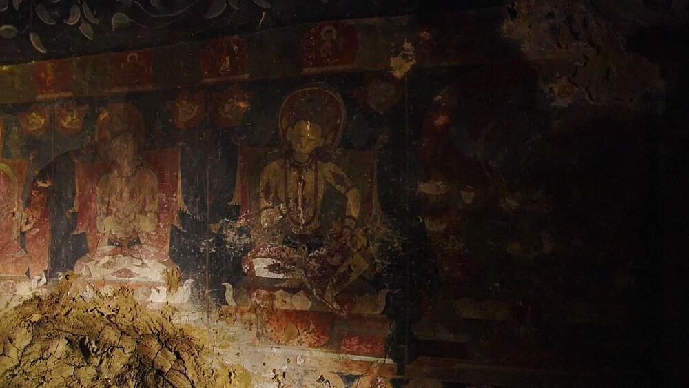 Slow pan over weathered 14th-century deity paintings on the wall of Luri Gompa cave monastery, Yara, Upper Mustang, Nepal