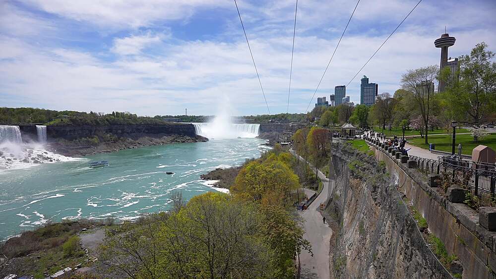 View of people on zip wires with the American Falls and Horseshoe Falls in background from Canada on a sunny day, Niagara Falls, Ontario, Canada, North America