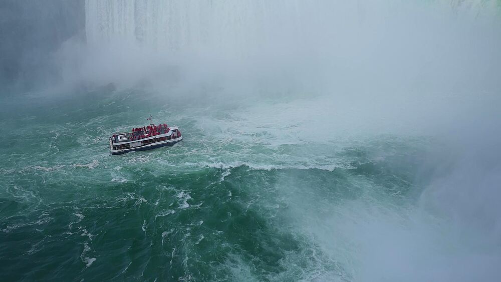 View of Maid of the Mist tour boat in Horseshoe Falls at sunset, Niagara Falls, Ontario, Canada, North America