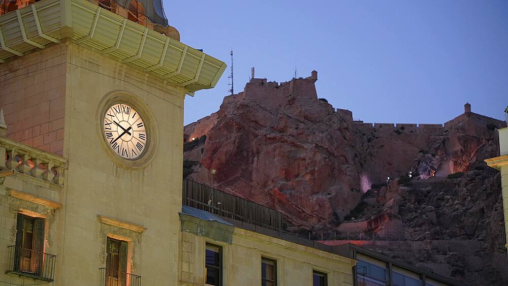 View of Alacant Town Hall Clock and Castillo de Santa Barbara in background at dusk in Alicante, Alicante, Costa Blanca, Spain, Europe