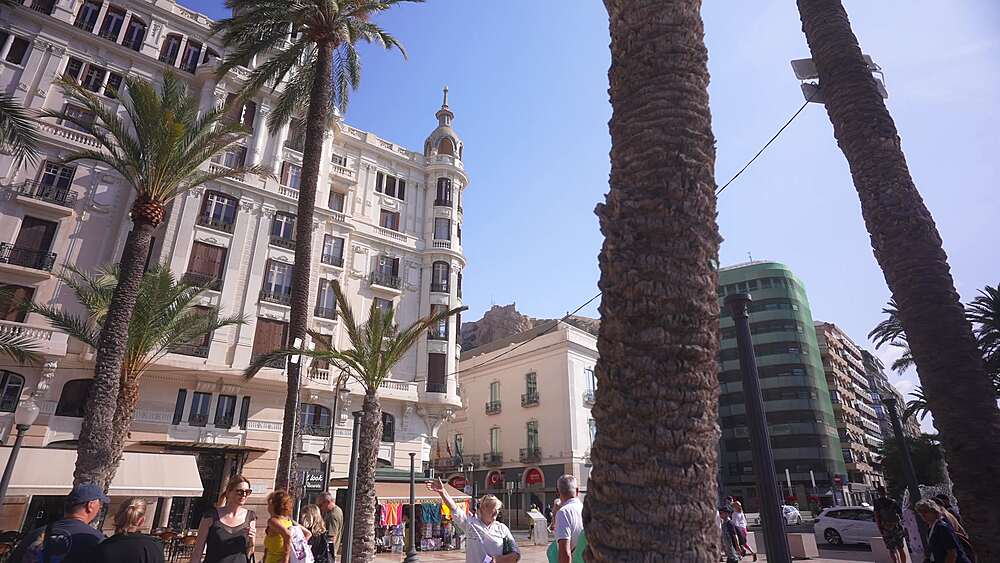 View of people on Explanada of Spain and Castillo de Santa Barbara in background on a sunny day, Alicante, Costa Blanca, Spain, Europe