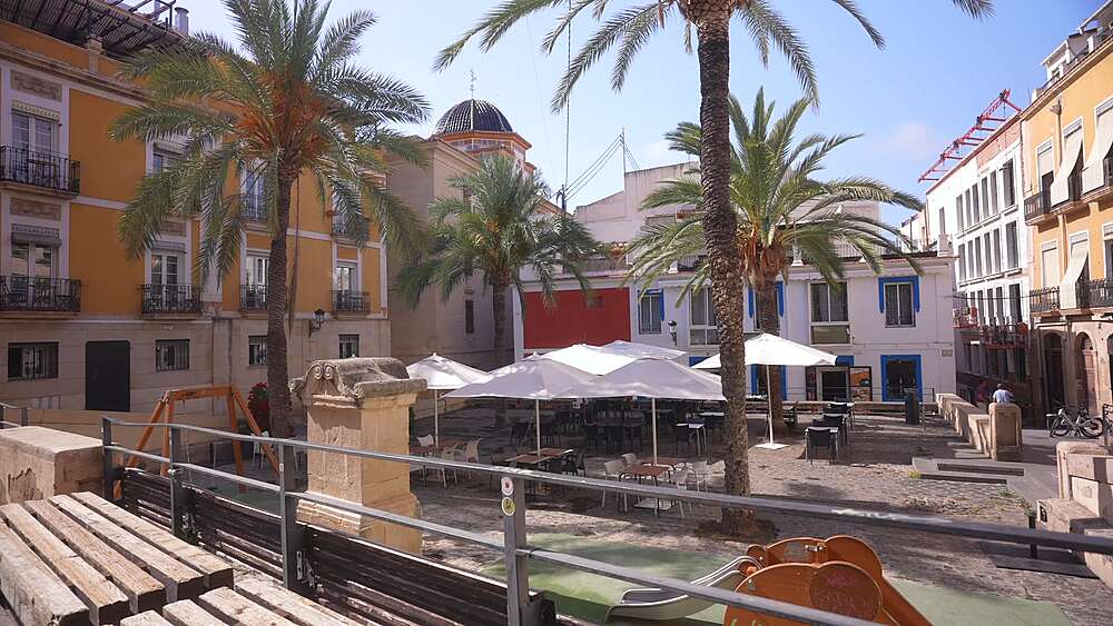 View of restaurants and palm trees in Placa de Quijano on a sunny day, Alicante, Costa Blanca, Spain, Europe