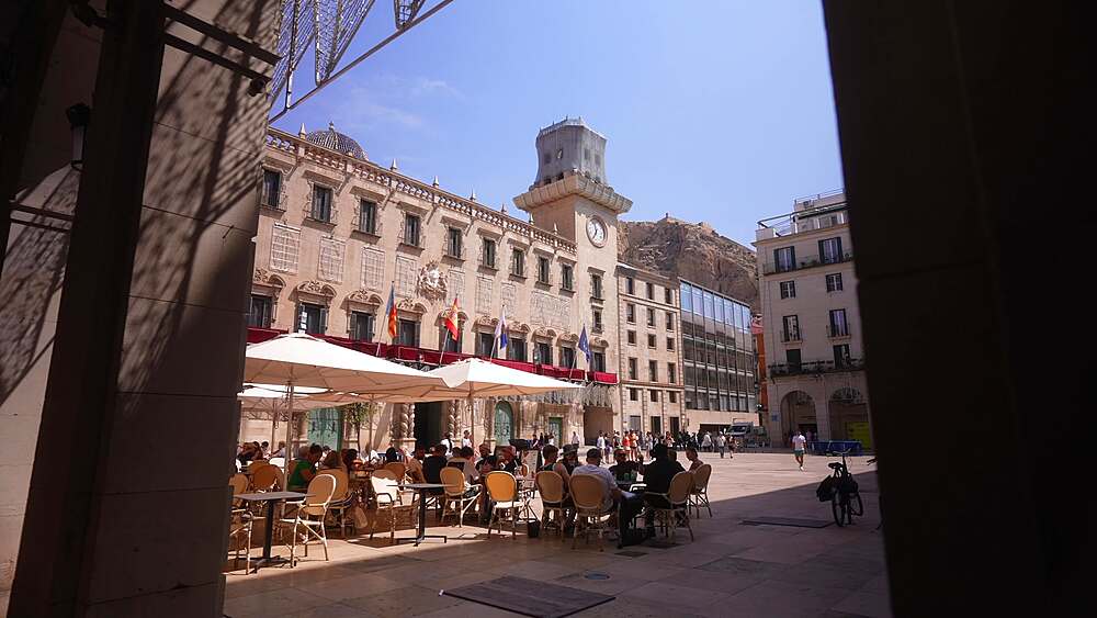 View of cafe in Alacant Town Hall Square and Castillo de Santa Barbara in background on a sunny day in Alicante, Alicante, Costa Blanca, Spain, Europe
