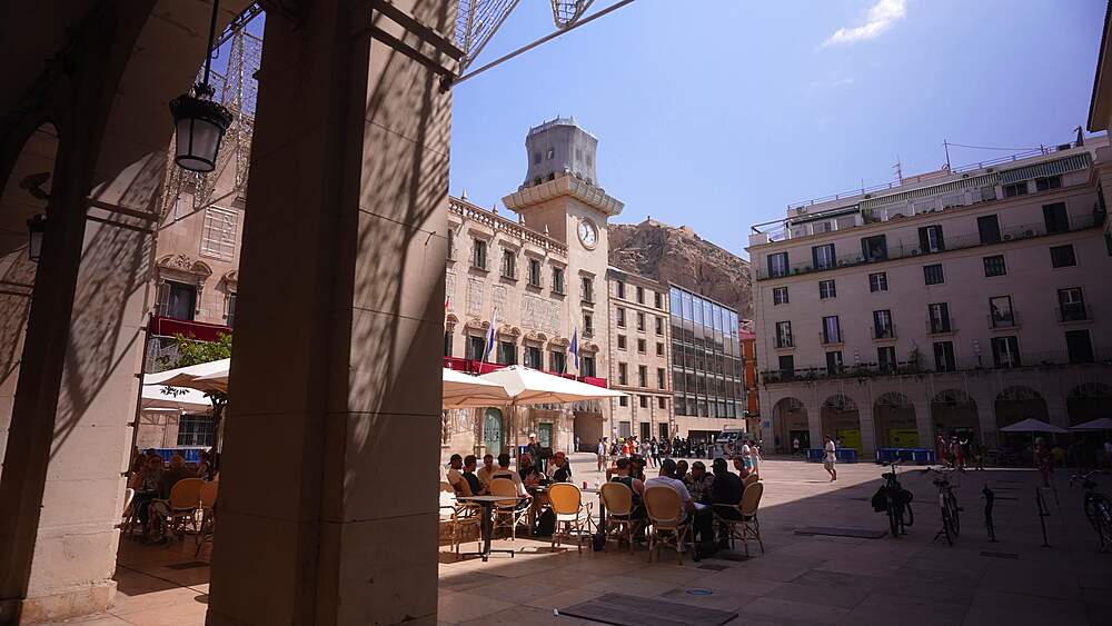 View of cafe in Alacant Town Hall Square and Castillo de Santa Barbara in background on a sunny day in Alicante, Alicante, Costa Blanca, Spain, Europe