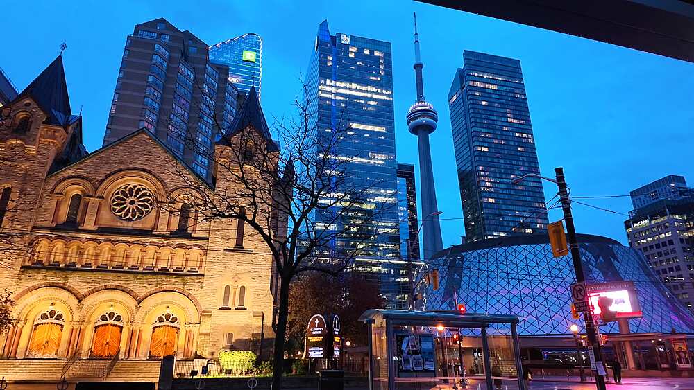 View of city trams, St. Andrew's Presbyterian Church, Roy Thomson Hall and CN Tower at dusk, Toronto, Ontario, Canada, North America
