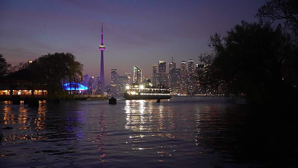 View of Centre Island Ferry, Toronto skyline and CN Tower from Middle Island at dusk, Toronto, Ontario, Canada, North America