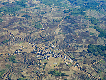 Charter flight view over a village in Madagascar showcasing farmland and rural landscape during daytime