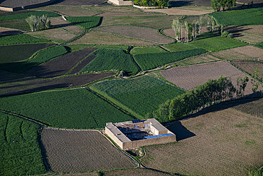 Rice fields surround a structure near Bamyian, showcasing farming practices in Afghanistan's agricultural landscape