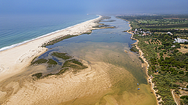 Long sandy beaches surround Cacela Velha in Algarve Portugal with river in view on a clear day