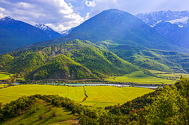 Breathtaking view of the mountains and river in Southeast Albania showcasing rich green fields and clear skies