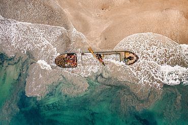 Shipwreck on a beach with blue water and crashing waves in Manzanillo, Costa Rica