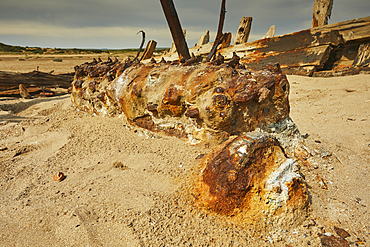 The rusting remains of a boat's engine, in a wreck at Crow Point, on the shore of the Taw and Torridge estuary, near Barnstaple, Devon, Great Britain.