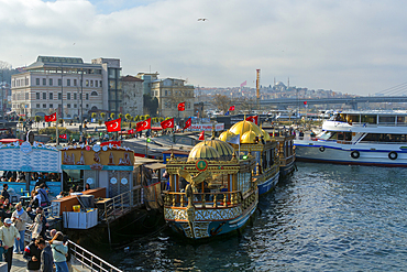 Golden domed boats from which sellers offer Balik Ekmek (fried fish sandwiches) on the Emin&ouml;n&uuml; waterfront. Istanbul, T&uuml;rkiye.