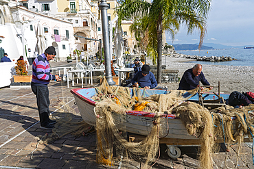 Fishermen repair their nets in Cetara, a fishing village along Italy's Amalfi Coast. Campania, Italy, Europe.