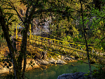 Suspension bridge crosses Cahabon River at sunrise in Semuc Champey area, Lanquin, Alta Verapaz, Guatemala