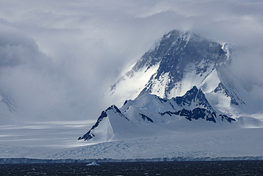 Ice capped mountains through fog and mist