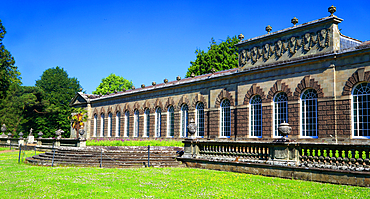 Margam Orangery with greenery and structure under clear blue sky at Margam Park near Port Talbot, South Wales