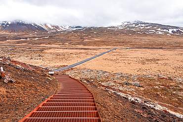Metal grid stairway descending Saxh&oacute;ll crater toward flat moorland and snow-capped mountains, Sn&aelig;fellsnes Peninsula, West Iceland