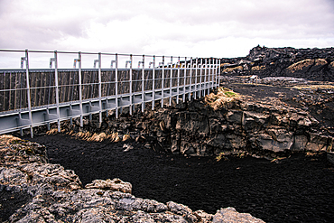 Leif the Lucky's Bridge spanning tectonic rift between two continents, close-up of steel railing and basalt walls of fissure, Sandvik, Route 425, Reykjanes Geopark, Iceland, Europe.