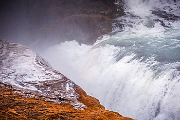 Turquoise glacial waters of Gullfoss waterfall plunging into the misty canyon over golden cliffs, Iceland. Iconic Golden Circle cascade on the Hv&iacute;t&aacute; river.