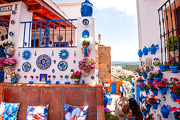 Patio de las Comedias, Izn&aacute;jar, C&oacute;rdoba, Andalusia, Spain. Blue flowerpots, painted ceramic plates and bright blooms decorating the whitewashed walls of the famous courtyard. Pueblo blanco and Andalusian colour
