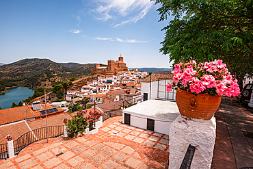 Iznájar, Córdoba, Andalusia, Spain. A terrace with potted pink geraniums overlooking the whitewashed village, castle and reservoir. Pueblo blanco and scenic Andalusian view<br />1372-4018 Iznájar, Córdoba, Andalusia, Spain. A terrace with potted pink geraniums overlooking the whitewashed village, castle and reservoir. Pueblo blanco and scenic Andalusian view