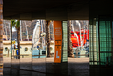 The Auditorio El Batel in Cartagena, Regi&oacute;n de Murcia, Spain. The glass fa&ccedil;ade reflects harbour masts and palms in bright daylight.