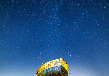 Star-filled sky over a boat on the Cumbrian Coast viewed from Rampside at night