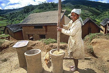 Young girl crushing rice, village in Central Highlands, Republic of Madagascar, Indian Ocean
