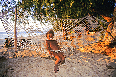 Little girl sitting in hammock on a beach of Tulear,Southern Madagascar, Indian Ocean, Southeast Africa